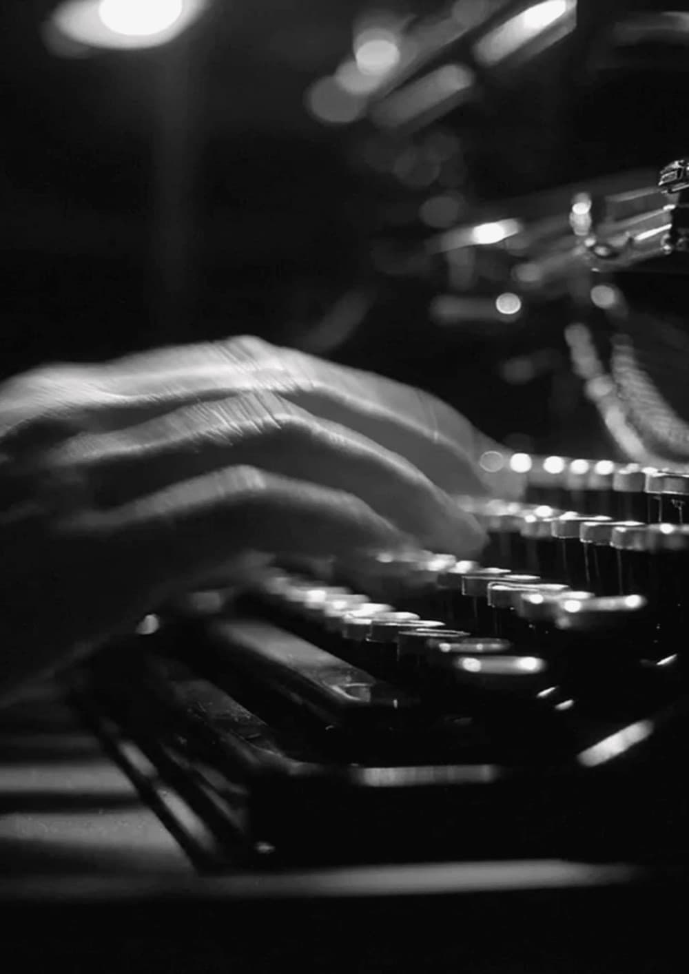 Hands on a typewriter, in black and white